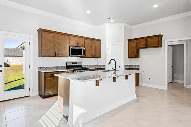 a kitchen with stainless steel appliances a stove top oven a sink a refrigerator and a microwave