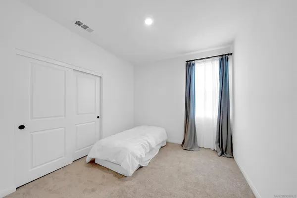 a spacious bedroom with a bed and a window