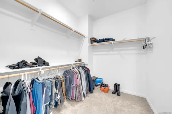 a view of walk in closet with clothes and shoes