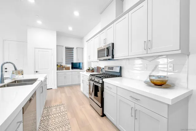 a kitchen with a sink a stove and cabinets