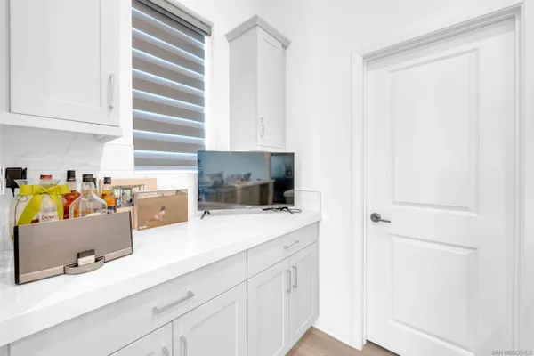 a living room with stainless steel appliances furniture cabinets and a window