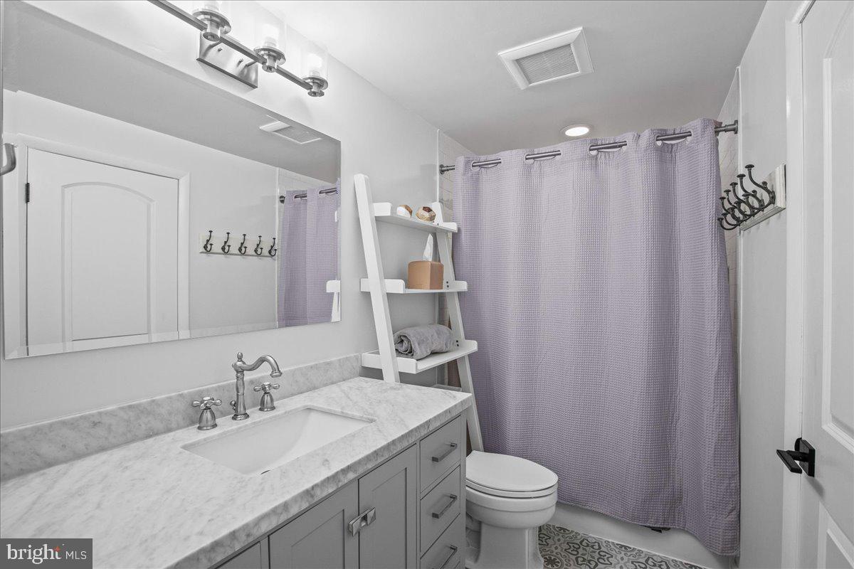 5829 Parakeet Drive Burke, VA 22015 - Photo 15 of 27 a bathroom with a granite countertop sink toilet and a mirror
