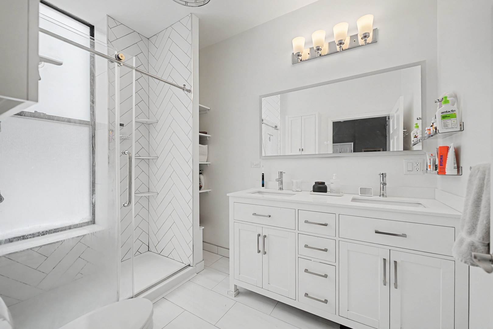 832 West Adams Street, Unit 2 Chicago, IL 60607 - Photo 13 of 23 a bathroom with a double vanity sink a mirror a bathtub and shower