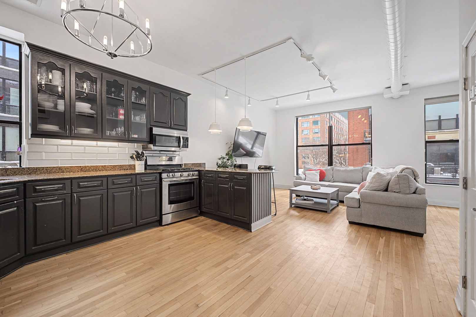 832 West Adams Street, Unit 2 Chicago, IL 60607 - Photo 8 of 23 a kitchen with stainless steel appliances granite countertop wooden floors and white cabinets