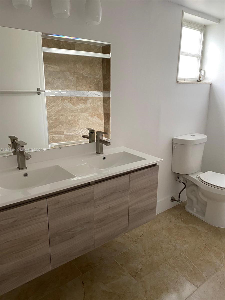1710 Northeast 191st Street, Unit 3013 Miami, FL 33179 - Photo 11 of 23 a bathroom with a sink toilet and a window