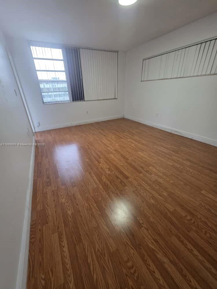 1710 Northeast 191st Street, Unit 3013 Miami, FL 33179 - Photo 15 of 23 an empty room with wooden floor and windows