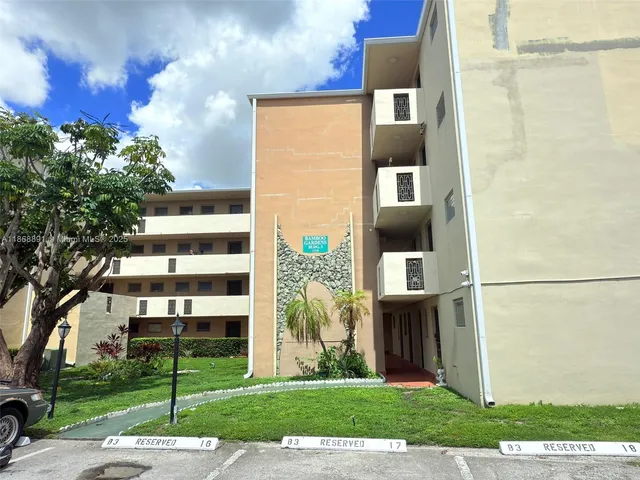 a front view of a building with a garden and plants