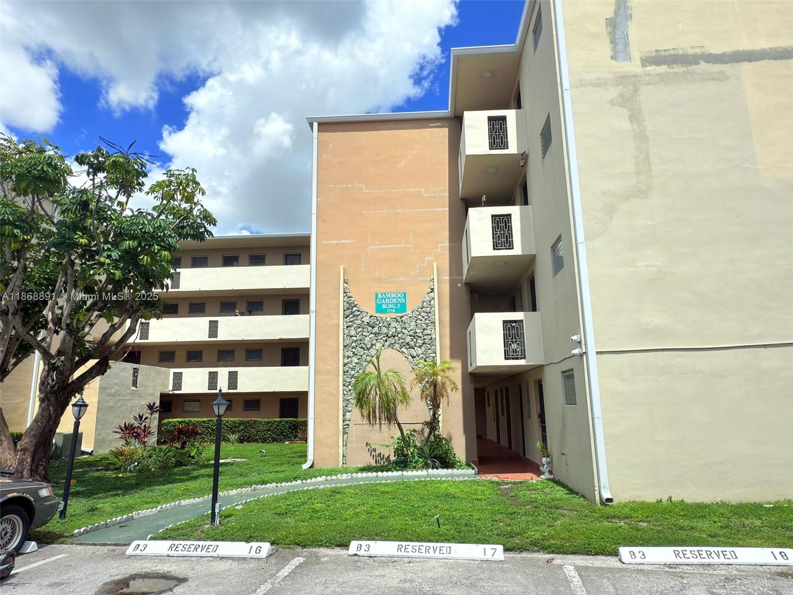 1710 Northeast 191st Street, Unit 3013 Miami, FL 33179 - Photo 3 of 23 a front view of a building with a garden and plants