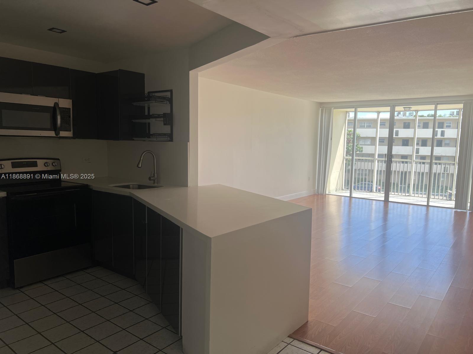 1710 Northeast 191st Street, Unit 3013 Miami, FL 33179 - Photo 7 of 23 a kitchen with a sink and cabinets