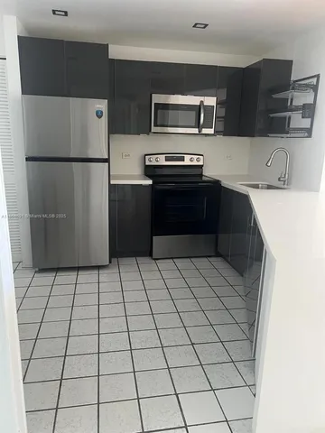 a kitchen with stainless steel appliances a refrigerator sink and cabinets