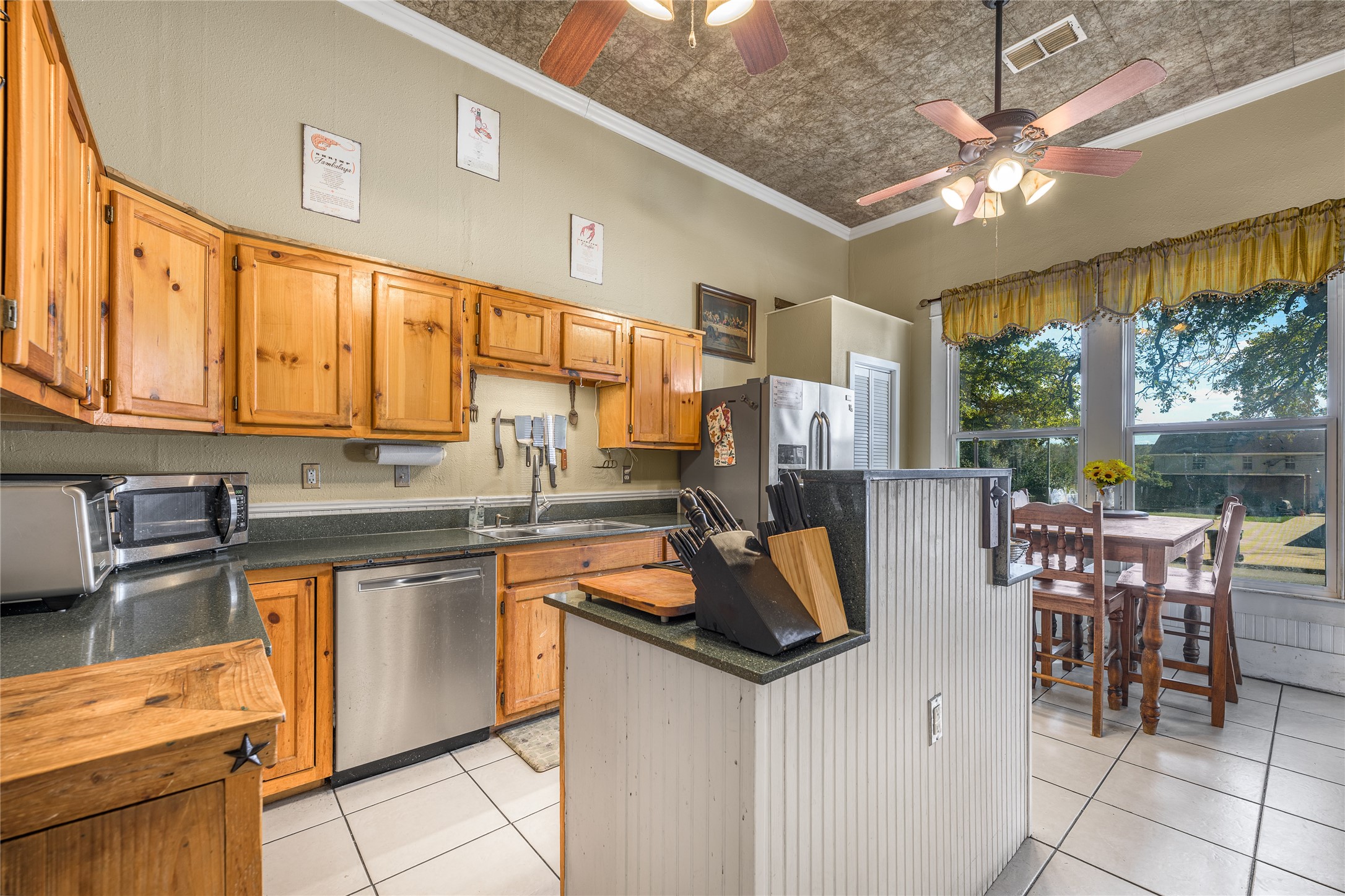 1000 North Park Street Brenham, TX 77833 - Photo 13 of 23 a kitchen with stainless steel appliances granite countertop a stove top oven a sink a dining table and chairs with the granite countertops