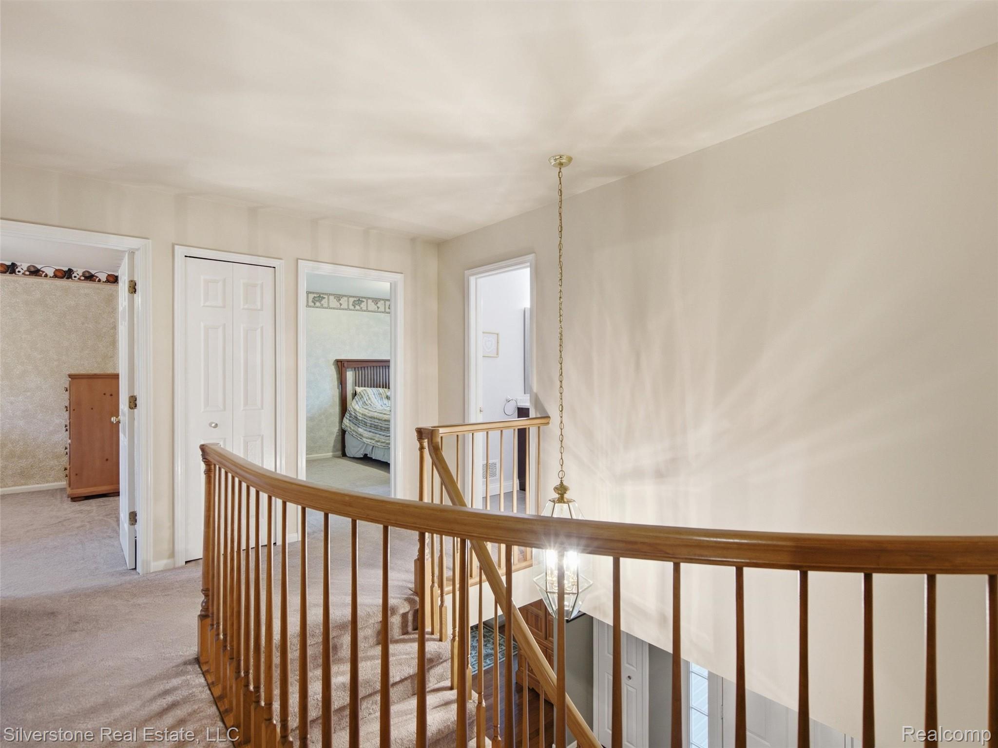 6577 Edith Court Troy, MI 48085 - Photo 33 of 61 Staircase with wood banister and spindles, illuminated by a hanging light fixture