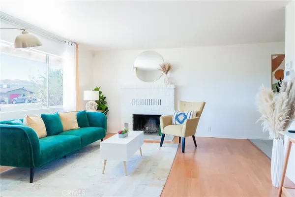 a living room with furniture a fireplace and a potted plant