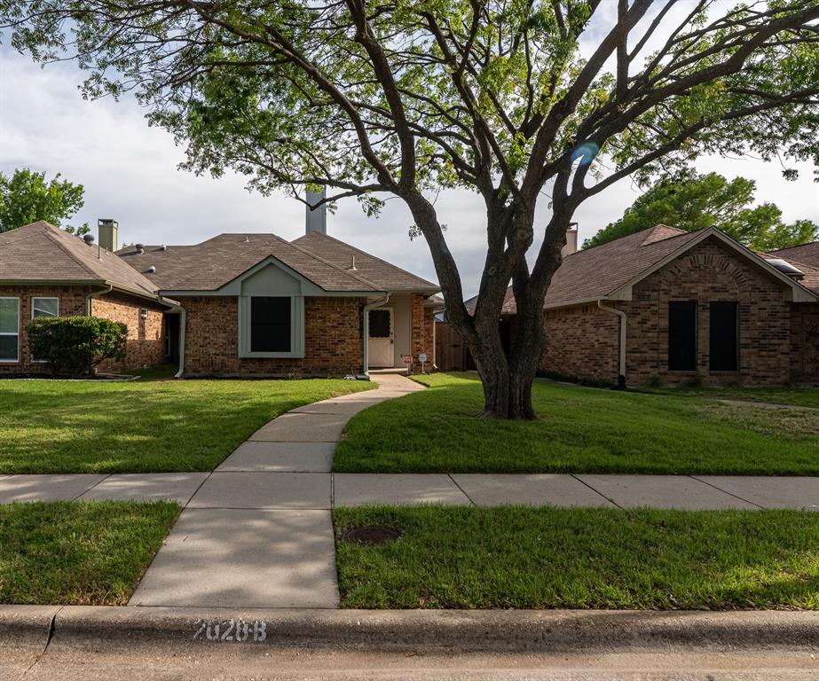 2028 Falcon Ridge Drive, Unit B Carrollton, TX 75010 - Photo 2 of 11 Ranch-style house featuring a front lawn, brick siding, and a chimney