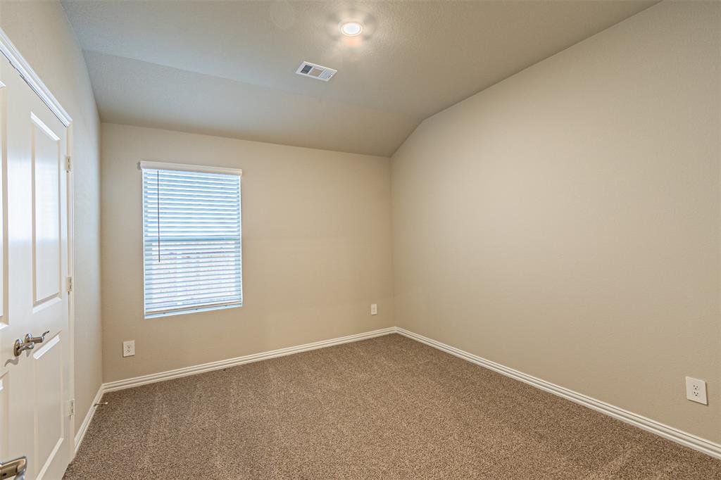 780 Moonlight Place Lavon, TX 75166 - Photo 11 of 35 Carpeted spare room with lofted ceiling and baseboards