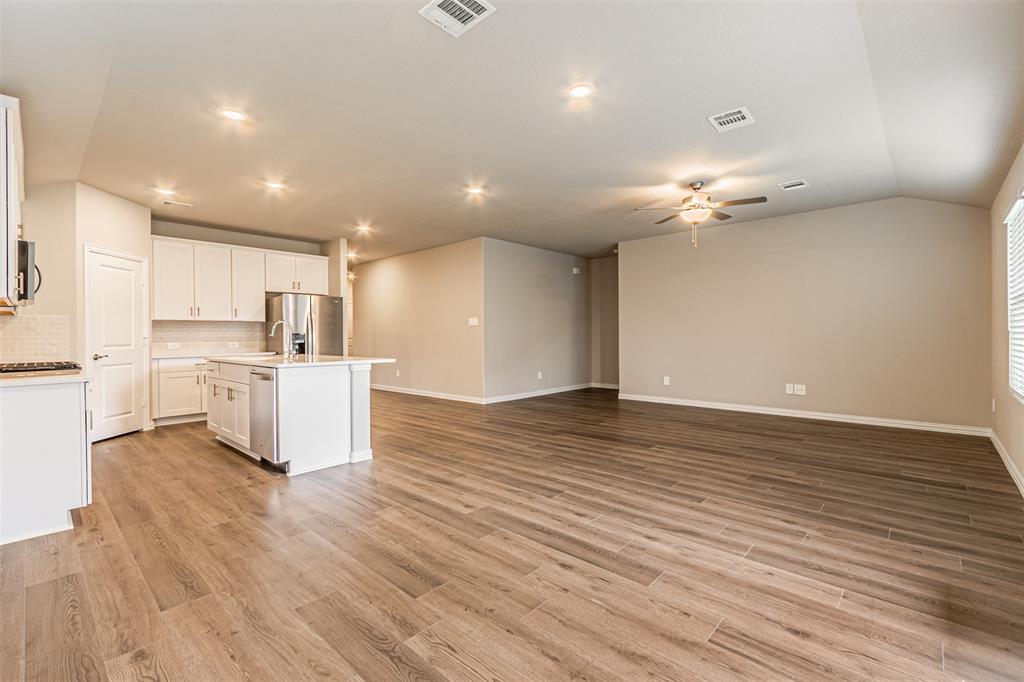 780 Moonlight Place Lavon, TX 75166 - Photo 35 of 35 Kitchen with an island with sink, open floor plan, tasteful backsplash, light wood-style flooring, and white cabinetry