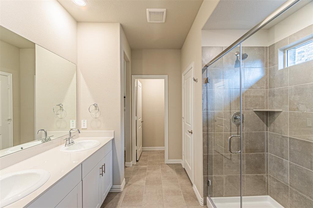 780 Moonlight Place Lavon, TX 75166 - Photo 23 of 35 Bathroom featuring double vanity, a shower stall, and light tile patterned floors