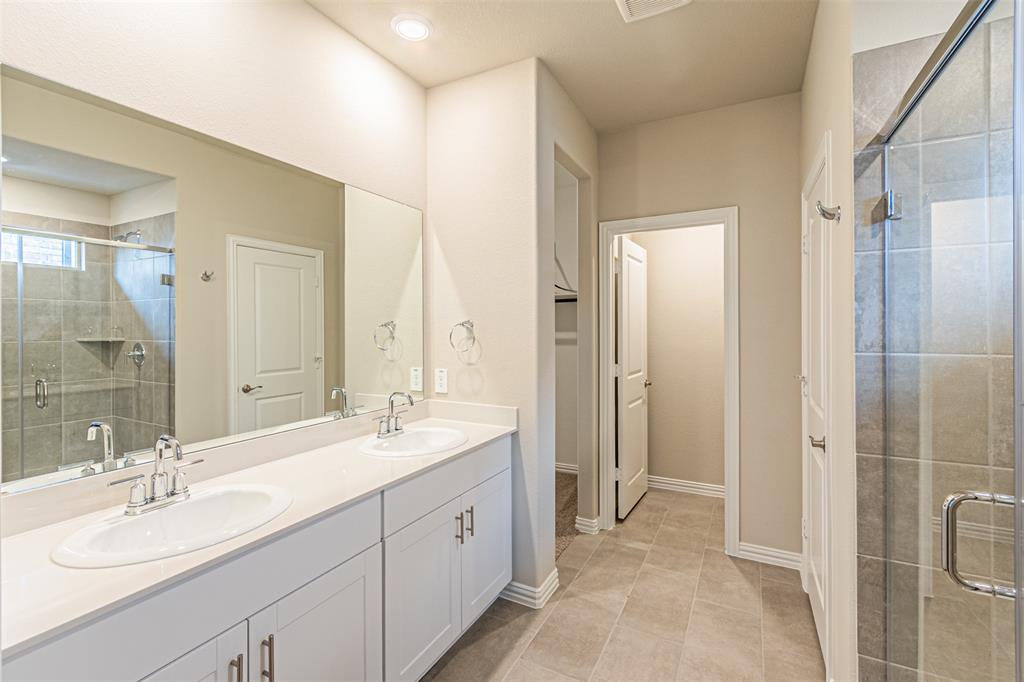 780 Moonlight Place Lavon, TX 75166 - Photo 24 of 35 Bathroom featuring a shower stall, double vanity, and light tile patterned floors