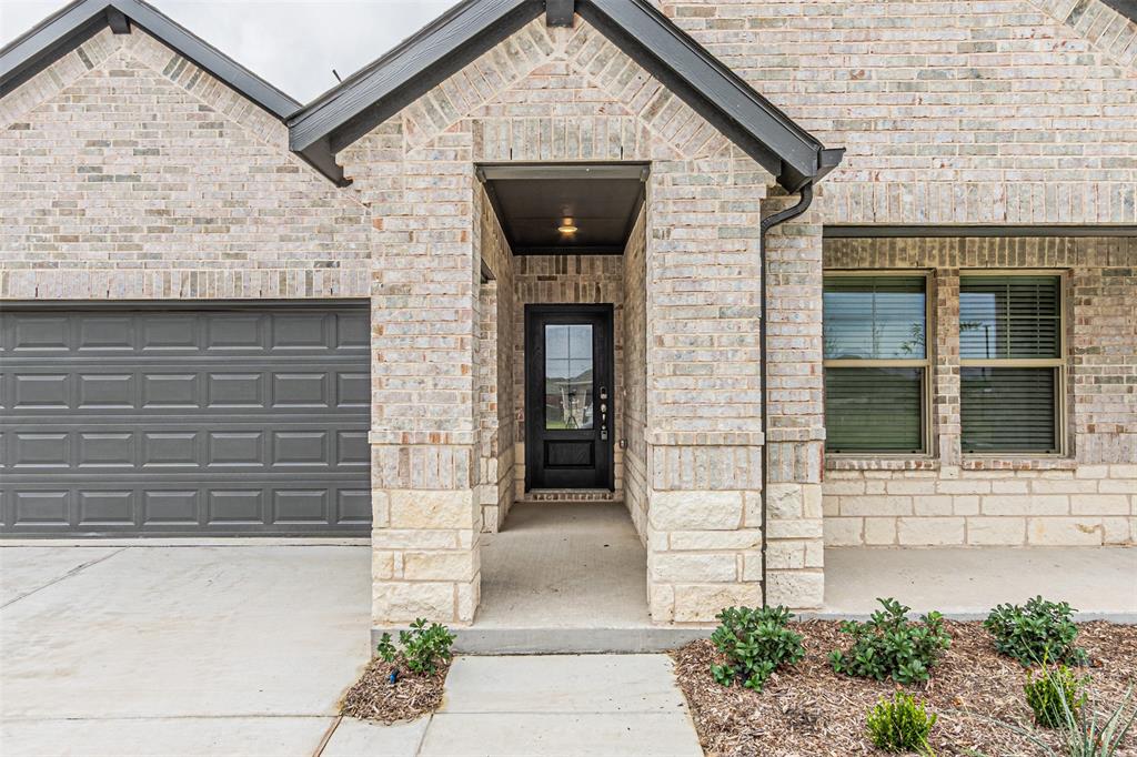 780 Moonlight Place Lavon, TX 75166 - Photo 4 of 35 Doorway to property with driveway, a garage, and brick siding