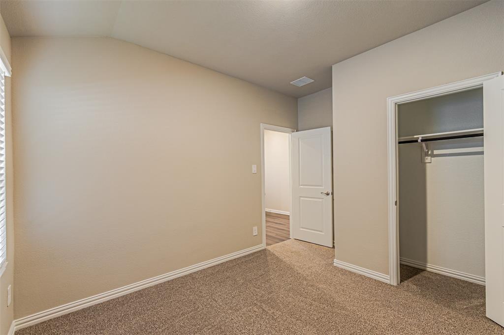 780 Moonlight Place Lavon, TX 75166 - Photo 10 of 35 Unfurnished bedroom featuring carpet floors, a closet, and lofted ceiling