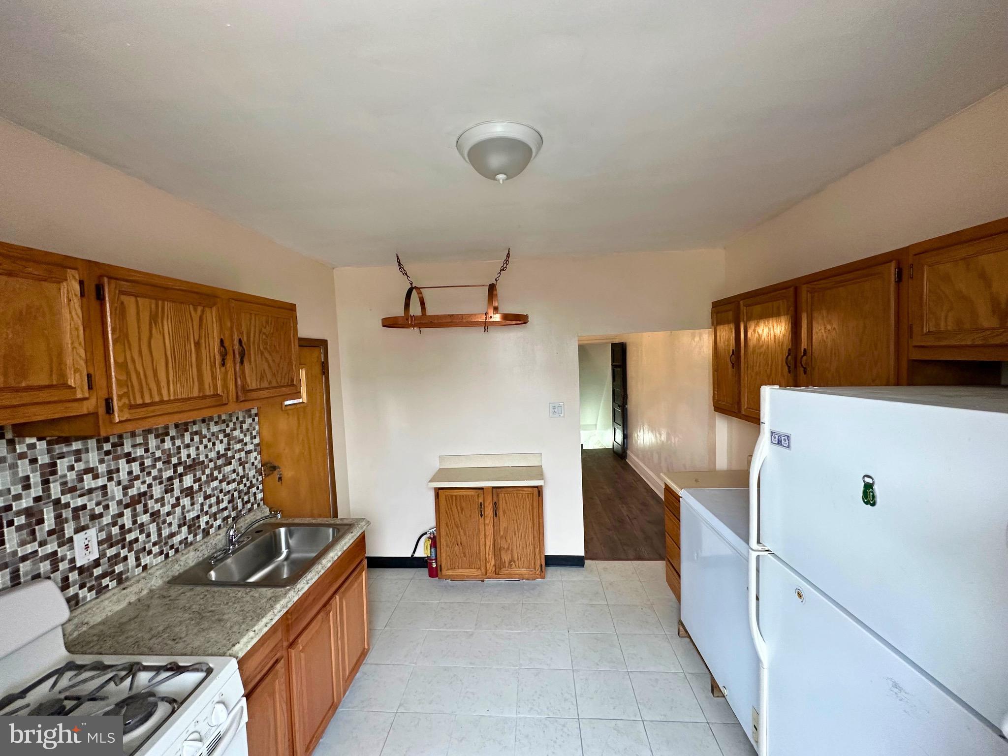 5332 Master Street Philadelphia, PA 19131 - Photo 4 of 17 a kitchen with granite countertop a stove and a refrigerator