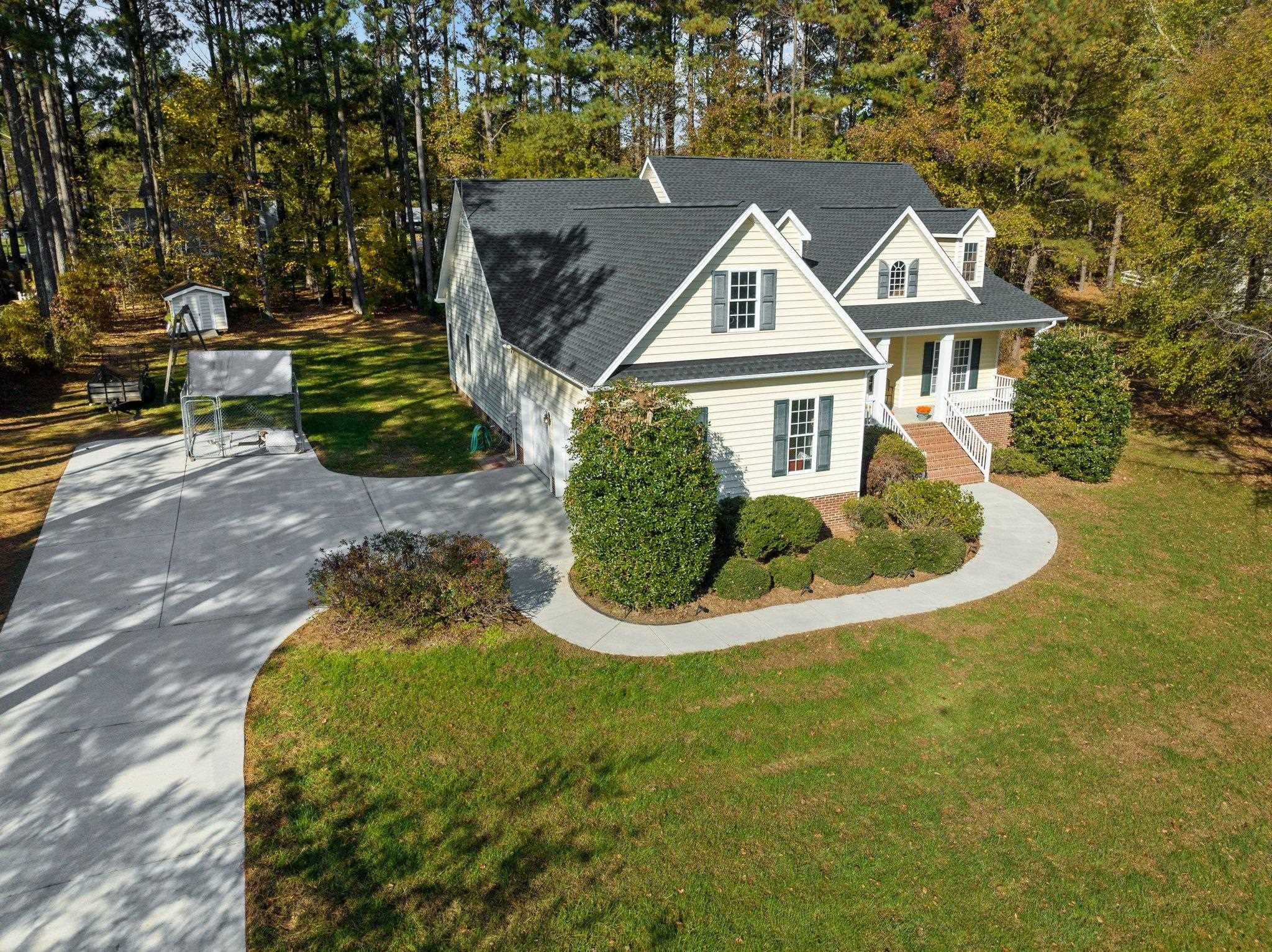 a view of a white house with a swimming pool and sitting area
