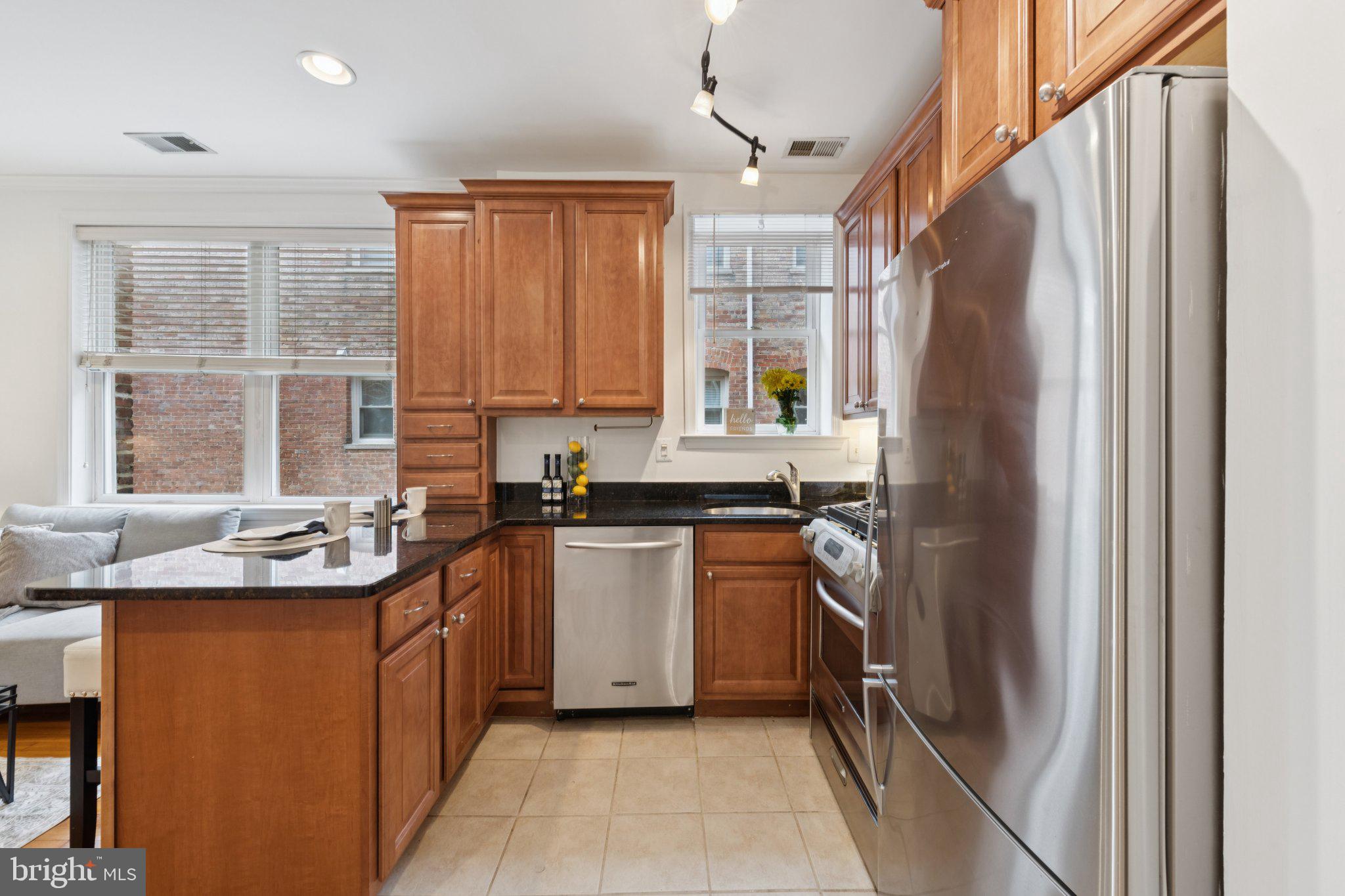 1438 Columbia Road Northwest, Unit 305 Washington, DC 20009 - Photo 11 of 22 a kitchen with stainless steel appliances granite countertop a refrigerator and a sink