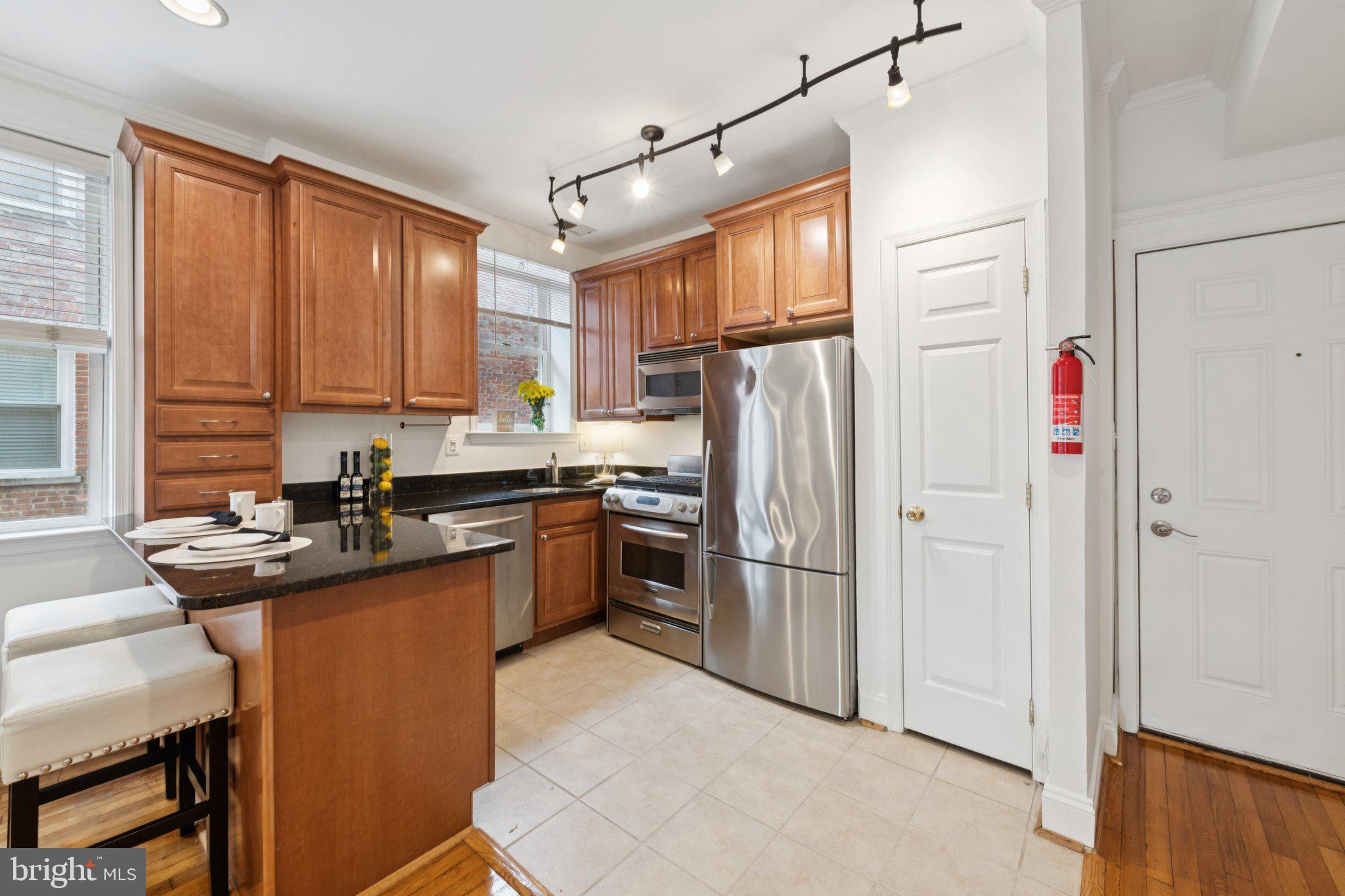 1438 Columbia Road Northwest, Unit 305 Washington, DC 20009 - Photo 3 of 22 a kitchen with stainless steel appliances granite countertop a refrigerator a sink dishwasher a stove and a refrigerator