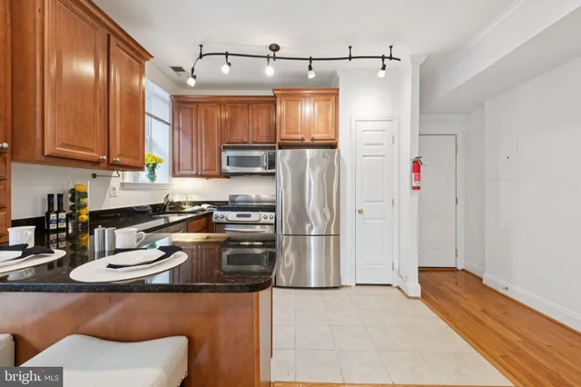 a kitchen with stainless steel appliances granite countertop a refrigerator and a sink