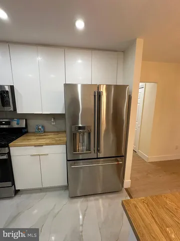 a kitchen with granite countertop a refrigerator and a sink