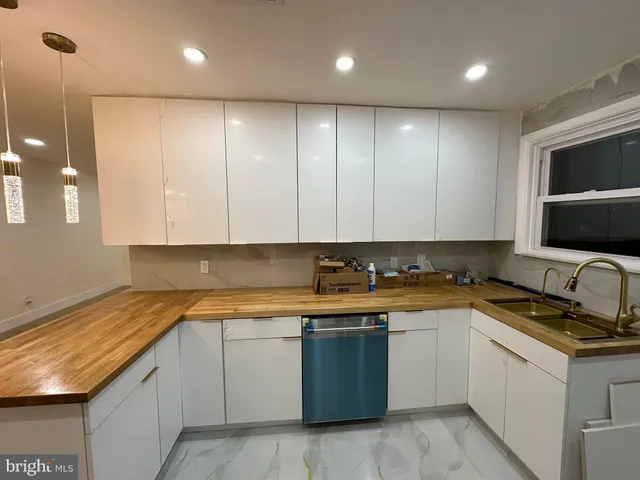 a kitchen with a sink stove top oven and cabinets
