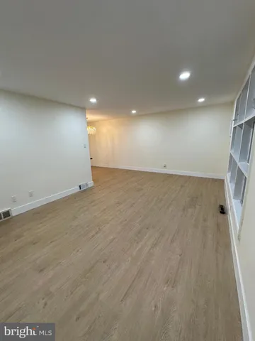 an empty room with wooden floor and entrance