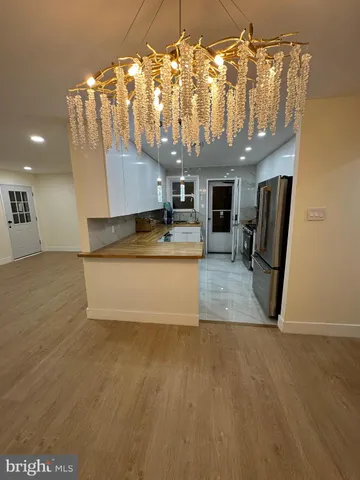 a view of a room with wooden floor and chandelier