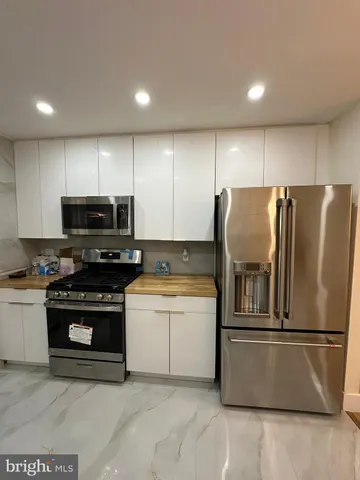 a kitchen with stainless steel appliances granite countertop a refrigerator a stove a sink and a microwave