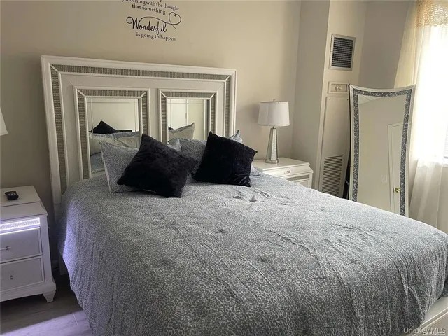 a bedroom with a bed and a large mirror