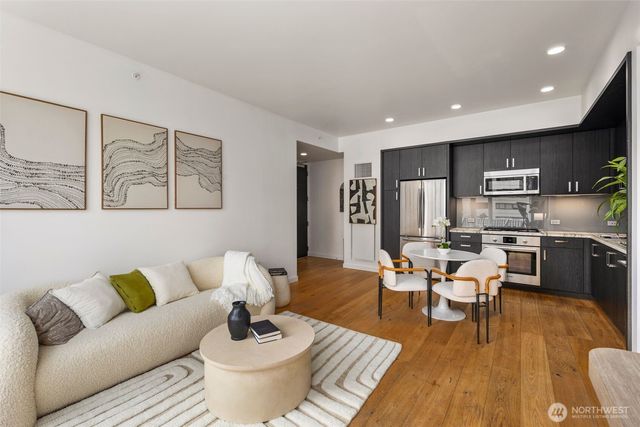 a living room with furniture kitchen view and a refrigerator