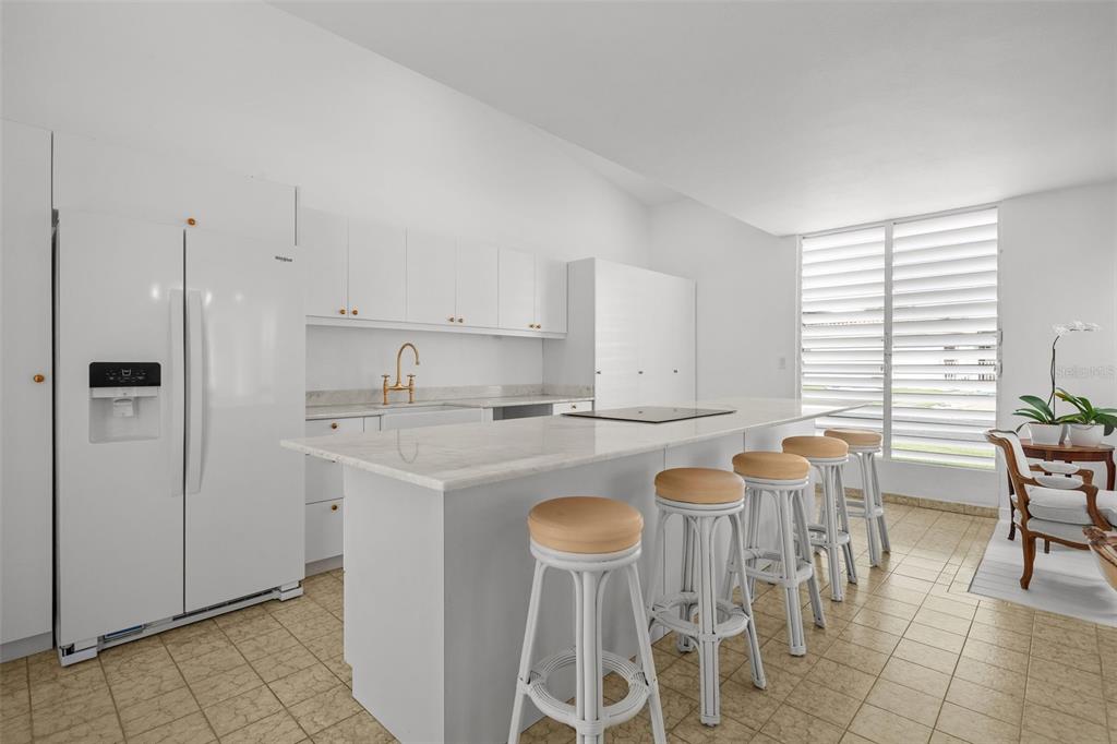 7 Barcelona Street Humacao, PR 00791 - Photo 3 of 16 a kitchen with a dining table chairs and a refrigerator