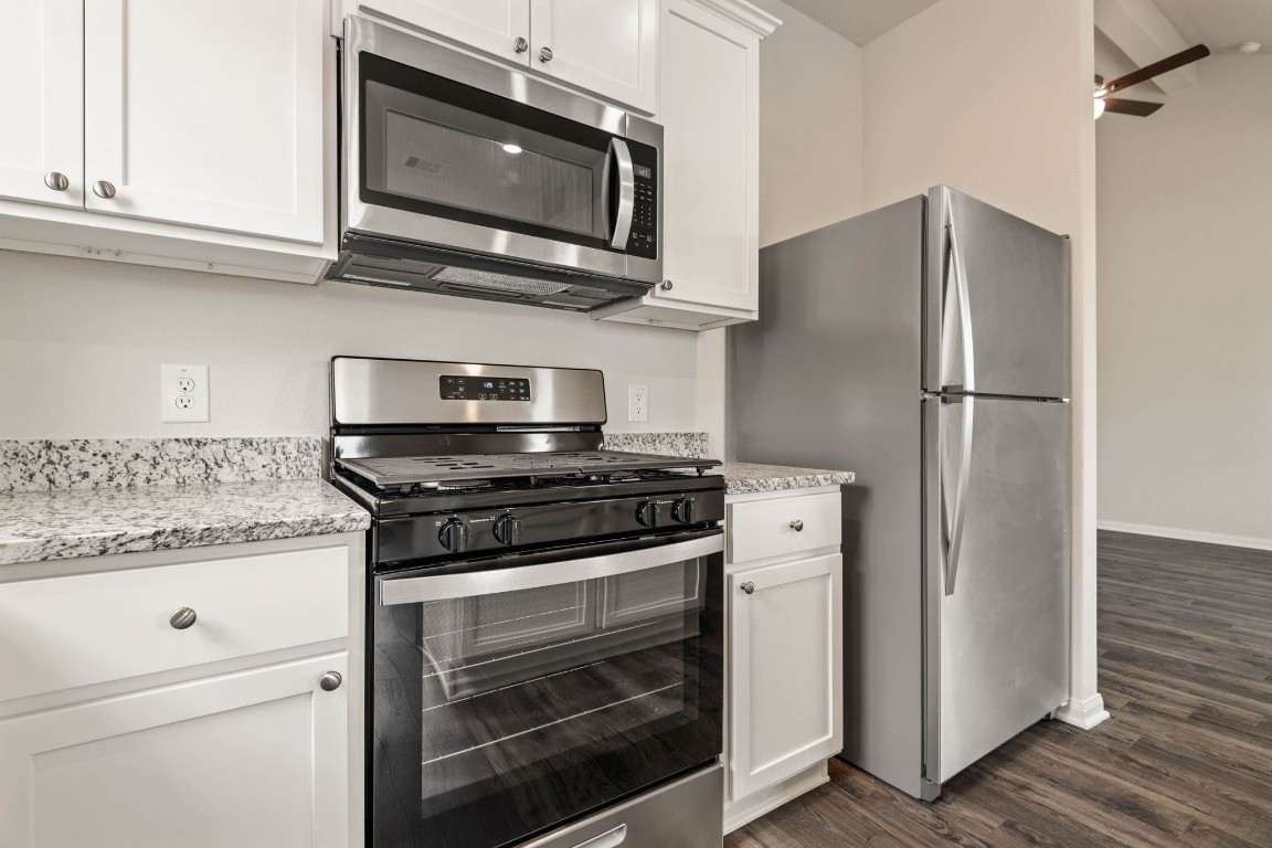 345 Fastboy Lane Waller, TX 77484 - Photo 8 of 12 a kitchen with stainless steel appliances white cabinets and a stove top oven