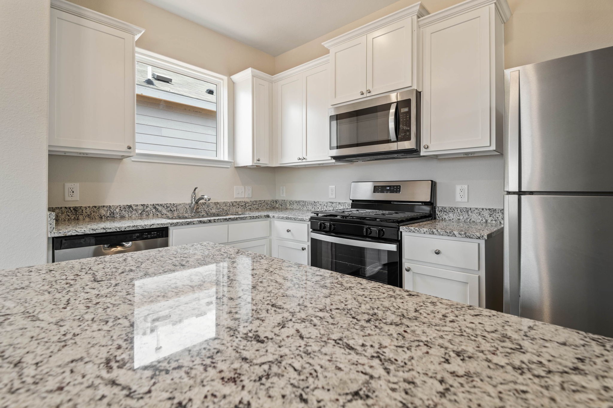 345 Fastboy Lane Waller, TX 77484 - Photo 9 of 12 a kitchen with granite countertop a refrigerator stove and microwave