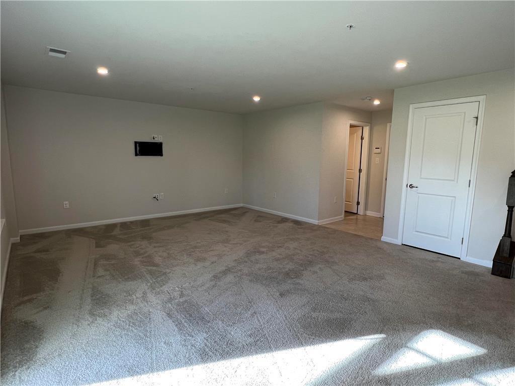 2356 Raya Way Easton, PA 18045 - Photo 21 of 28 Recessed lighting illuminates a versatile living space finished with neutral carpet.