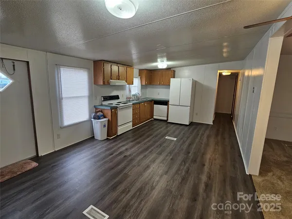 a large kitchen with a wooden floor and stainless steel appliances
