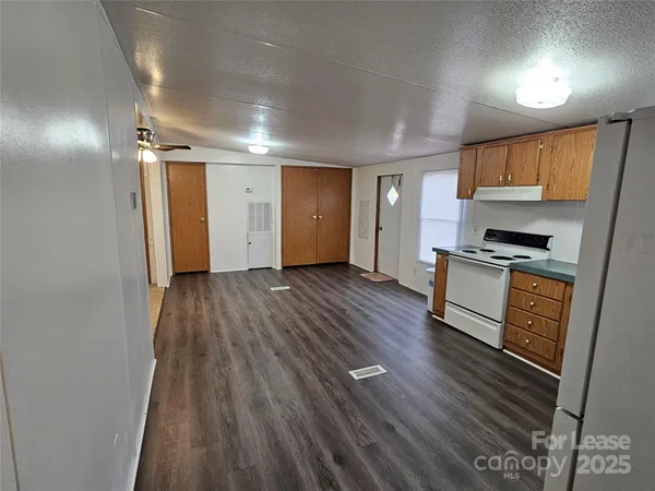 a view of kitchen with sink and refrigerator
