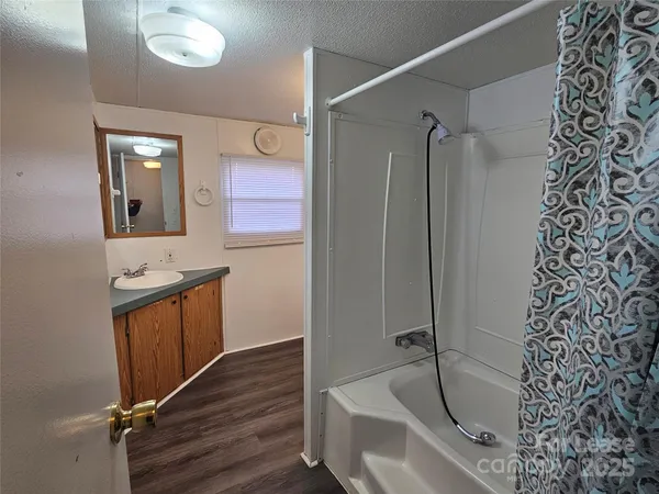 a bathroom with a tub sink and mirror