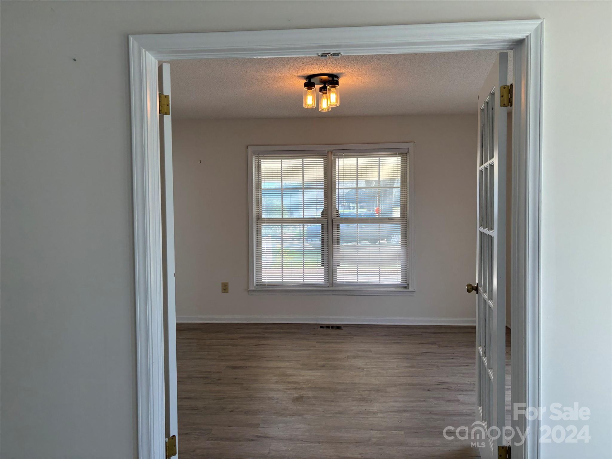 2145 East Holly Grove Road Lexington, NC 27292 - Photo 11 of 19 a view of an empty room with wooden floor and a window