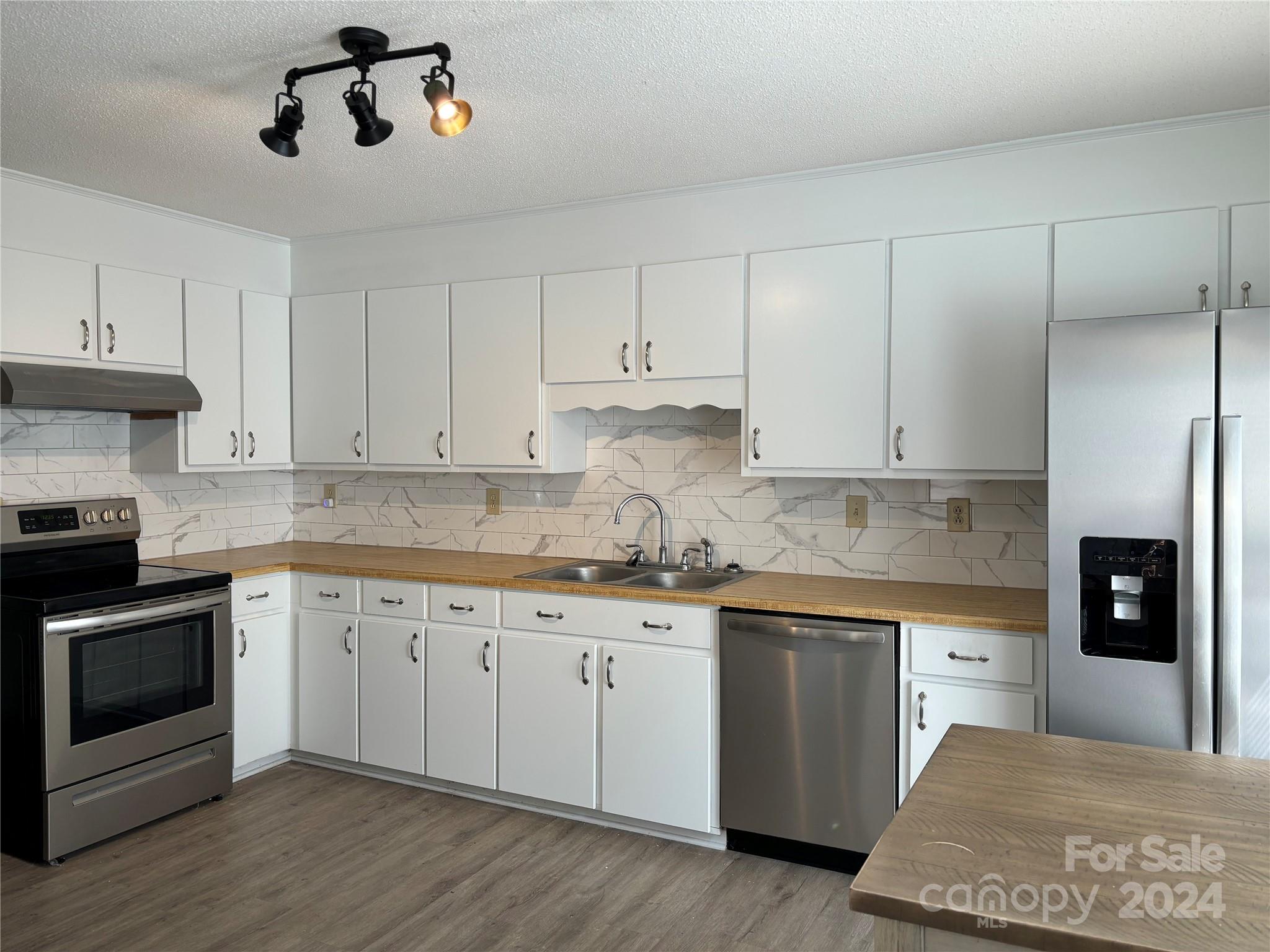 2145 East Holly Grove Road Lexington, NC 27292 - Photo 13 of 19 a kitchen with granite countertop white cabinets and stainless steel appliances