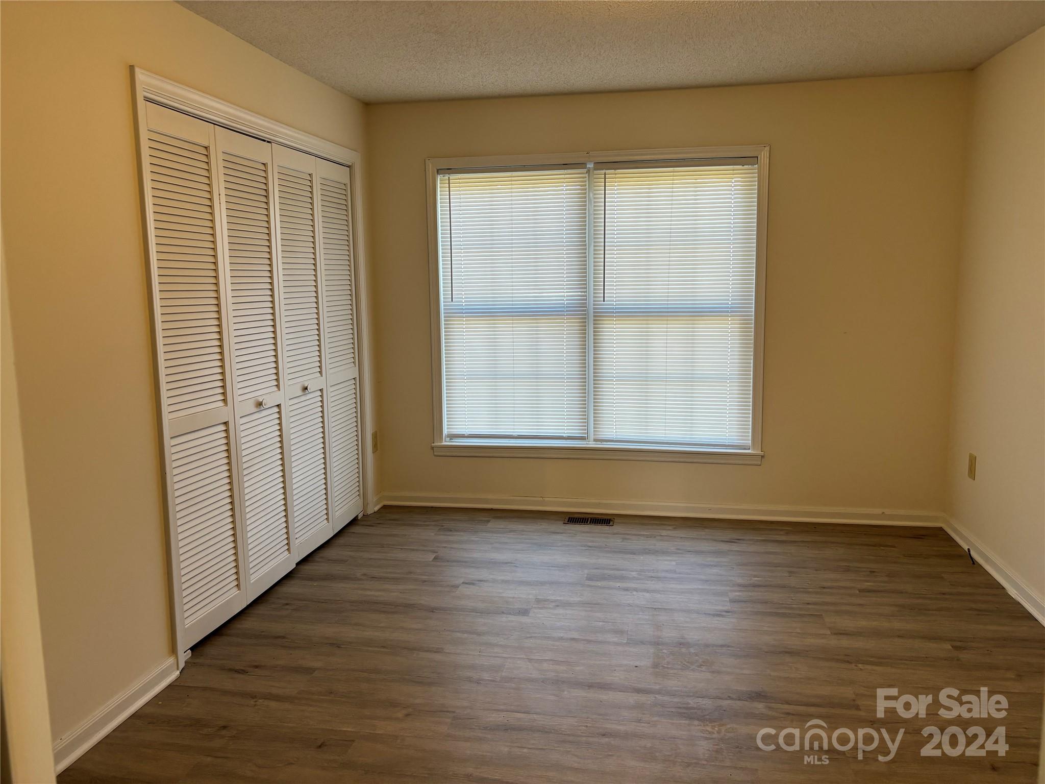 2145 East Holly Grove Road Lexington, NC 27292 - Photo 16 of 19 an empty room with wooden floor and windows