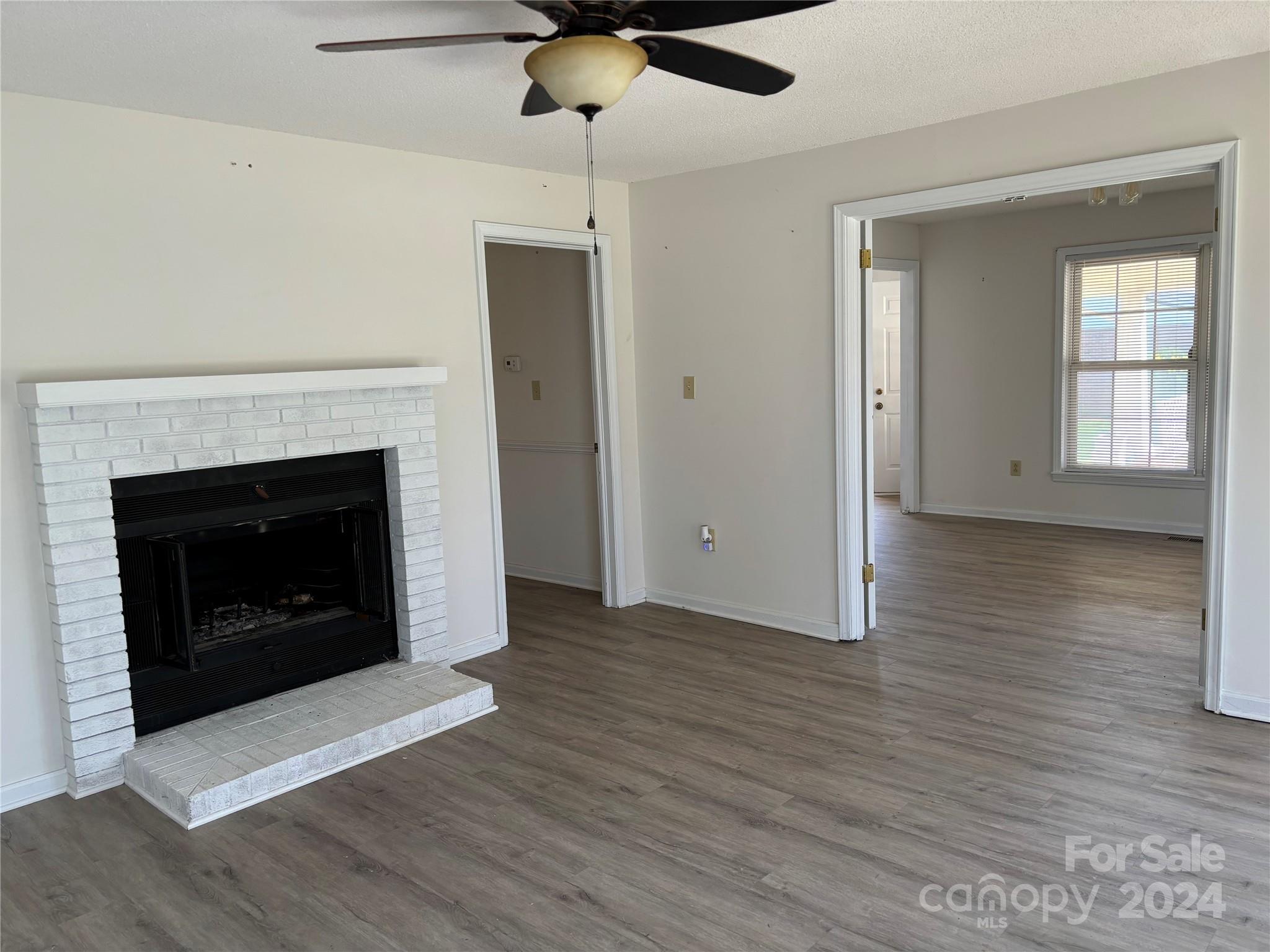 2145 East Holly Grove Road Lexington, NC 27292 - Photo 8 of 19 a view of an empty room with wooden floor fireplace and a window
