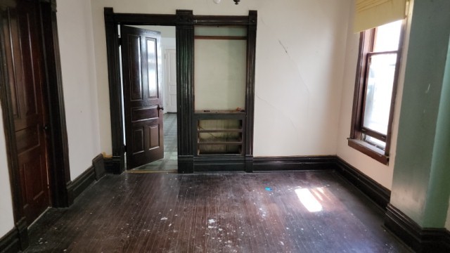 5751 South Carpenter Street Chicago, IL 60621 - Photo 3 of 10 an empty room with wooden floor and windows