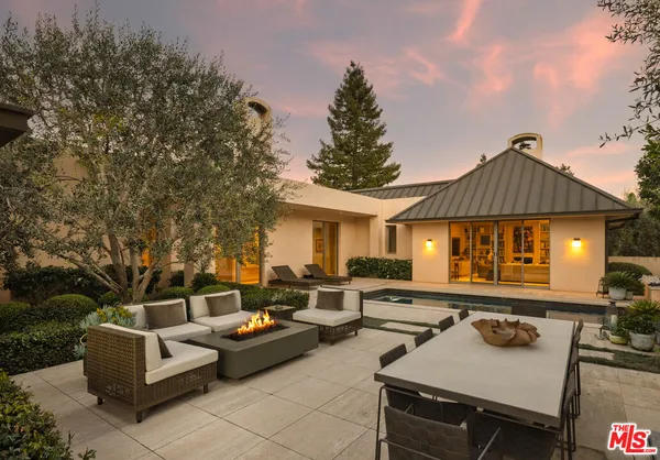 a view of a patio with couches a table and chairs with wooden fence