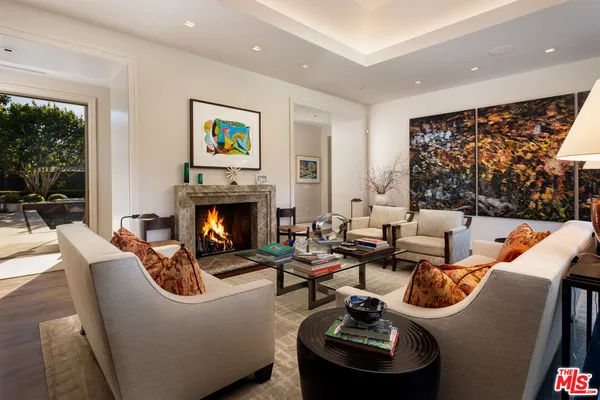 a living room with furniture a fireplace and a floor to ceiling window